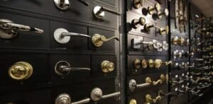 A variety of door handles on display, showcasing different styles and designs. The handles are mounted on a dark set of drawers, each with a label beneath it, in a well-organized arrangement.