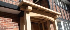 Wooden porch attached to a brick house with a timber frame and flat roof.