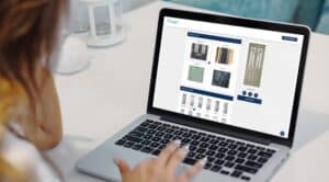 Person browsing door designs on a laptop, selecting options from an online catalogue.